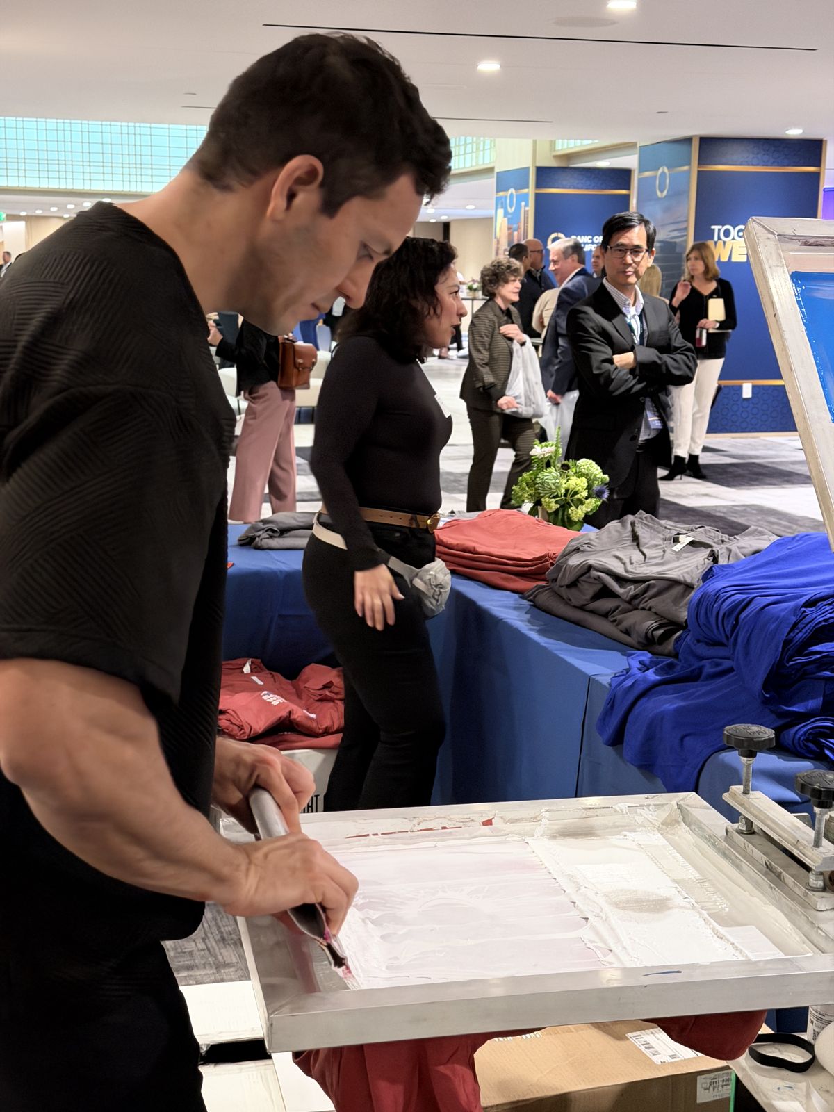 Expo station with folded apparel colors staged behind the working press area