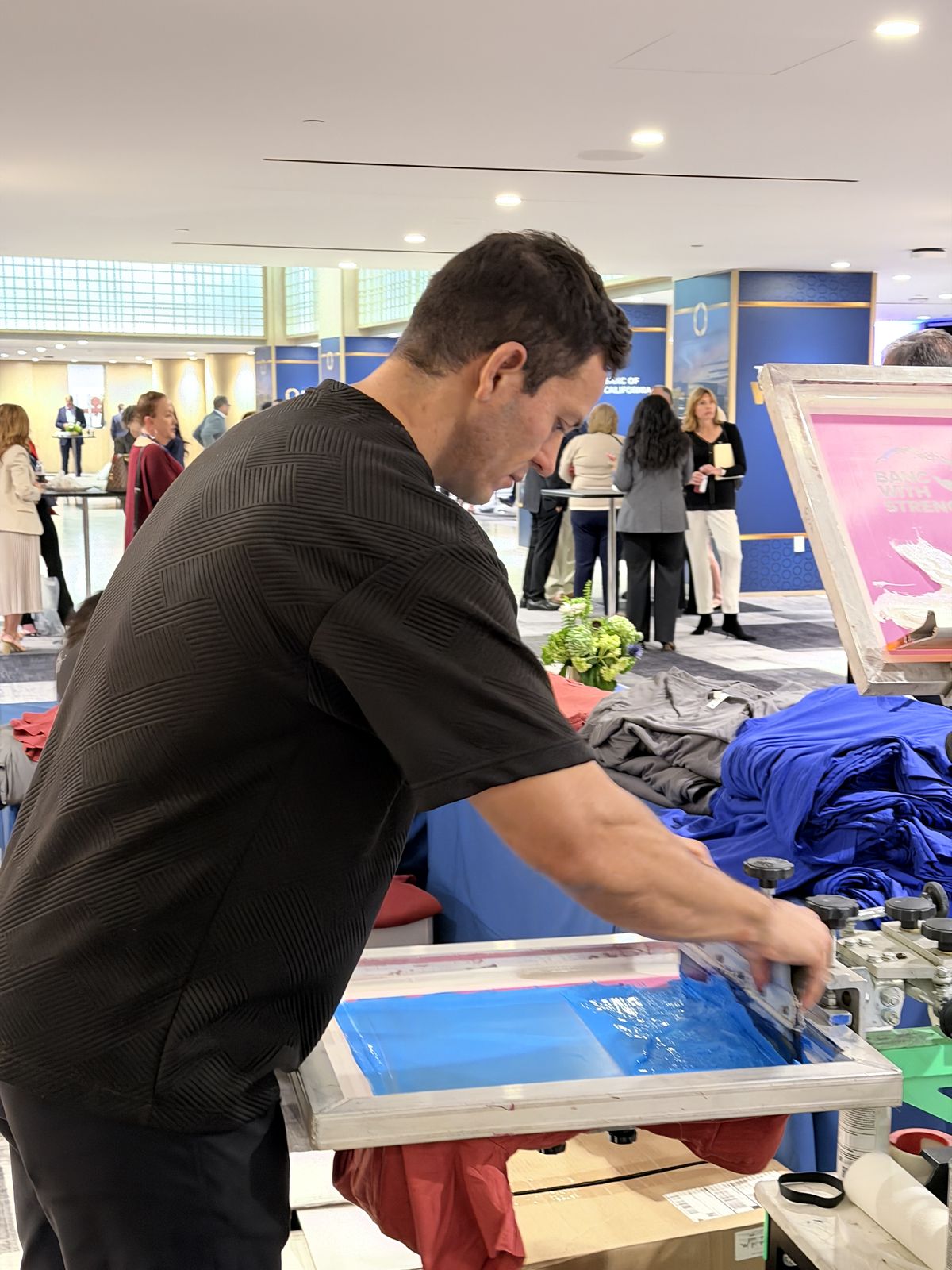 Crew member pulling a squeegee across a screen at a conference activation